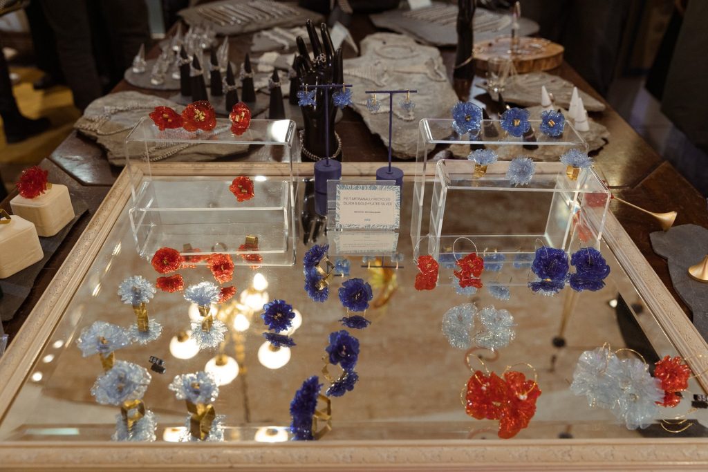 Mesa de espejo con flores azules y rojas expuestas en el local